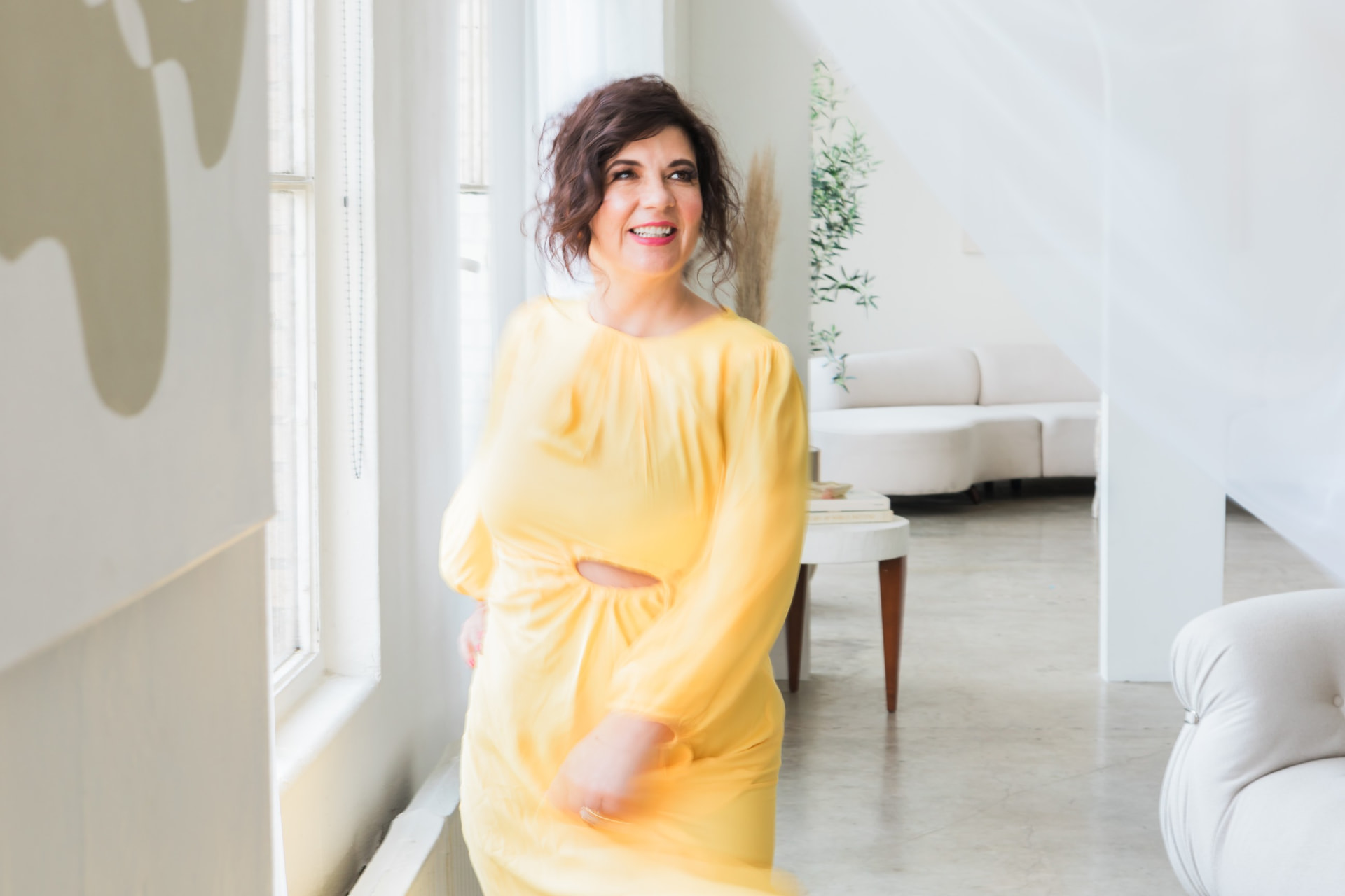 Cynthia Ferngren in a yellow dress by a window